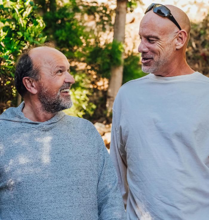 Two men taking a walk and talking on a sunny afternoon.