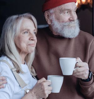 Senior couple drinking coffee outside on a chilly day.
