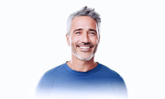 Attractive man with short grey hair, wearing a blue shirt smiling at the camera.