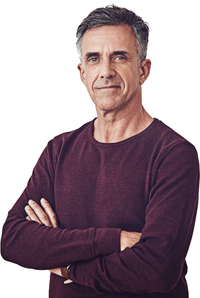 Mature man standing with arms crossed, smiling.