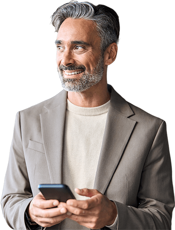 Senior man in a suit holding a mobile phone looking to his right, smiling about the great plan he found on healthpilot.
