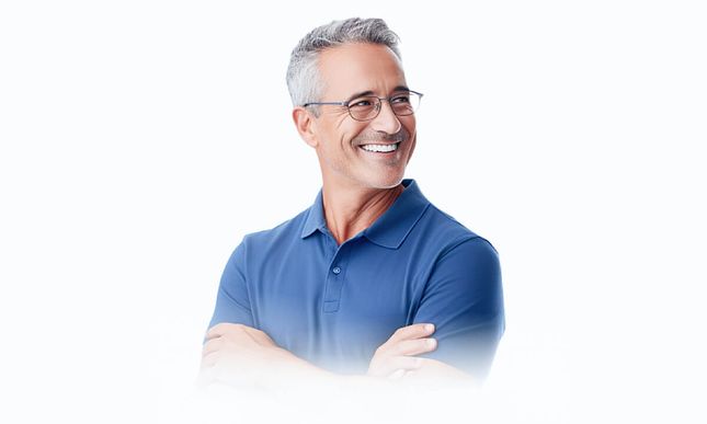 Clean cut senior man in blue polo shirt and glasses smiling.